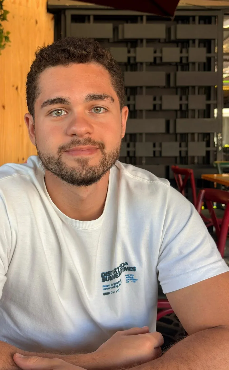 Enzo Gagliardi, psicólogo, de camiseta branca, olhando para a câmera