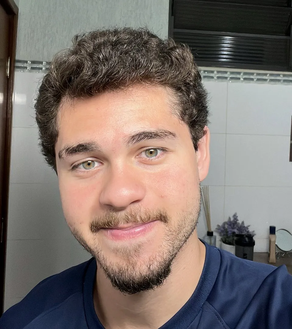 Enzo Gagliardi, psicólogo, de camiseta azul-marinho, sorrindo