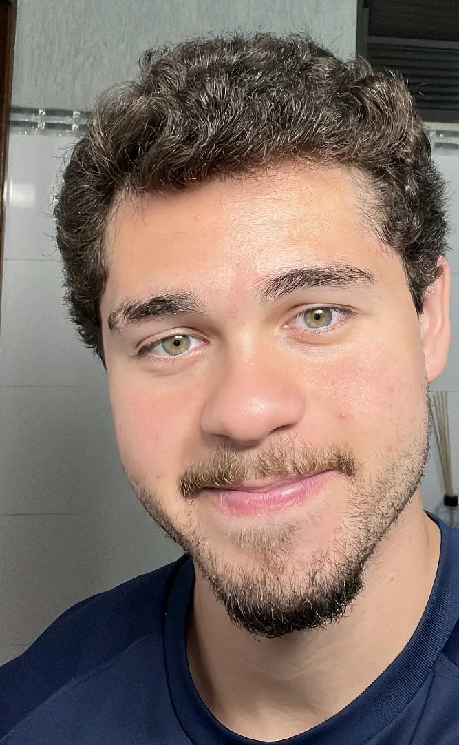 Enzo Gagliardi, psicólogo, de camiseta azul-marinho, sorrindo